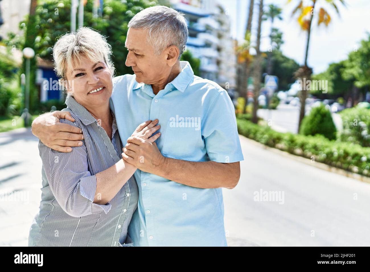 Middle age caucasian couple of husband and wife together on a sunny day outdoors. Smiling happy