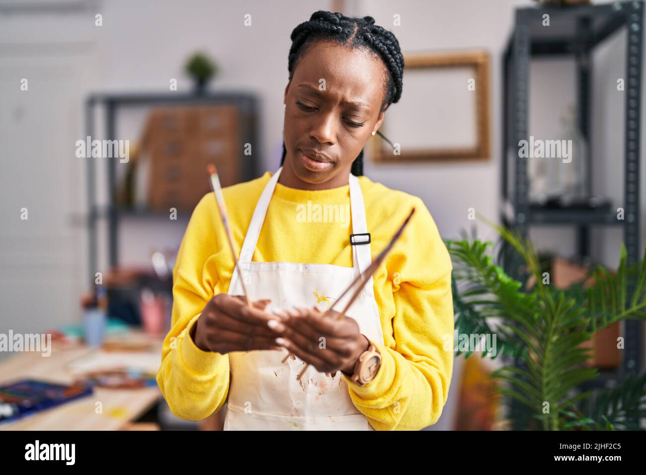 African american woman artist holding paintbrushes at art studio Stock ...