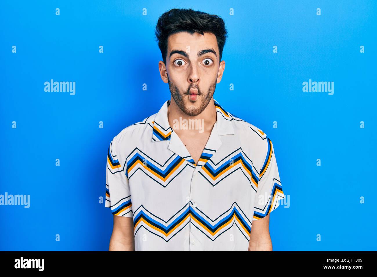 Young hispanic man wearing casual clothes making fish face with lips, crazy and comical gesture. funny expression. Stock Photo
