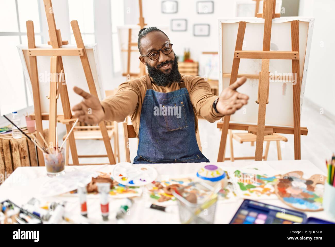 African american artist man at art studio looking at the camera smiling ...