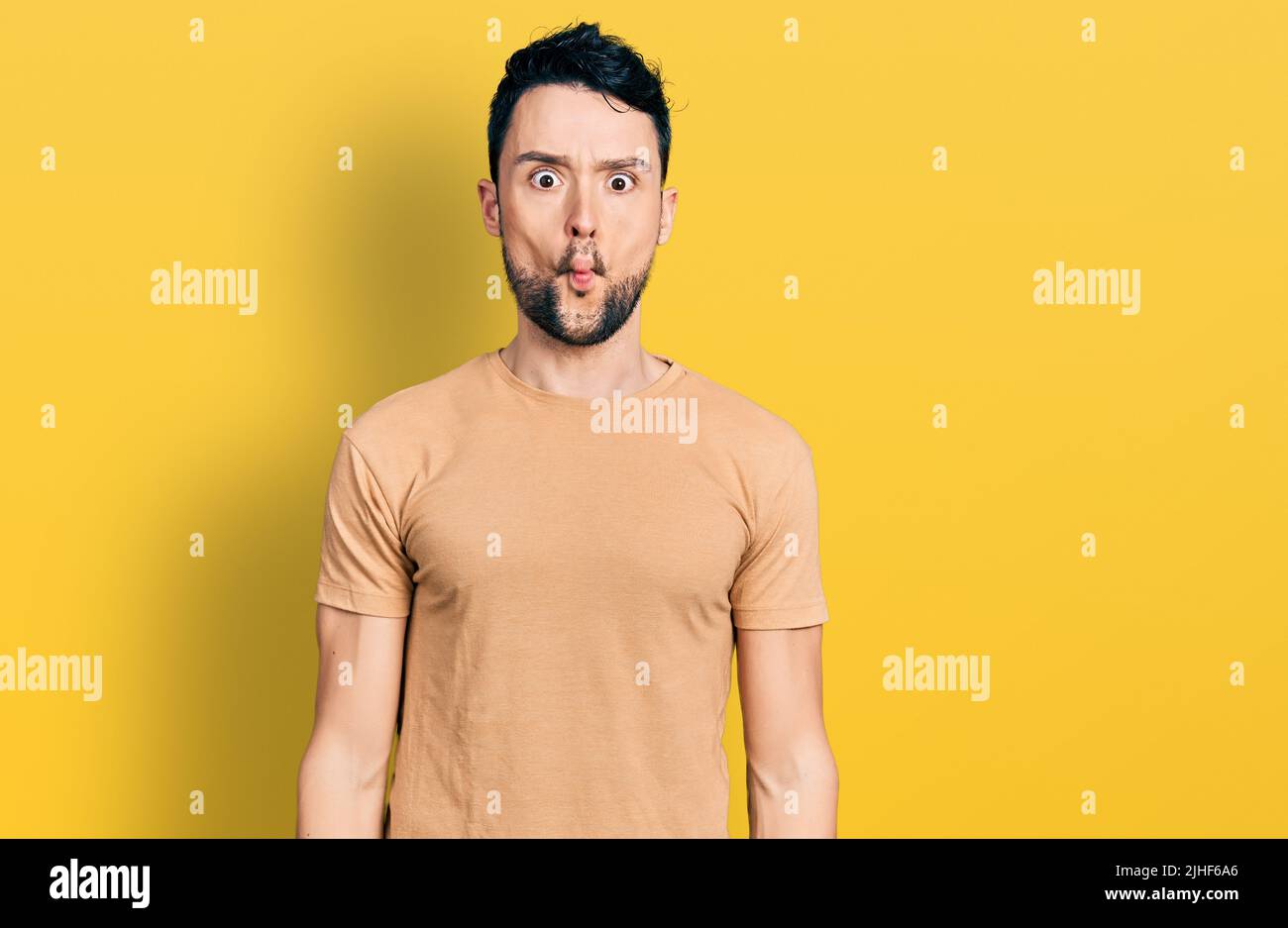 Teenager boy wearing yellow t-shirt over isolated background making fish  face with lips, crazy and comical gesture. Funny expression Stock Photo -  Alamy