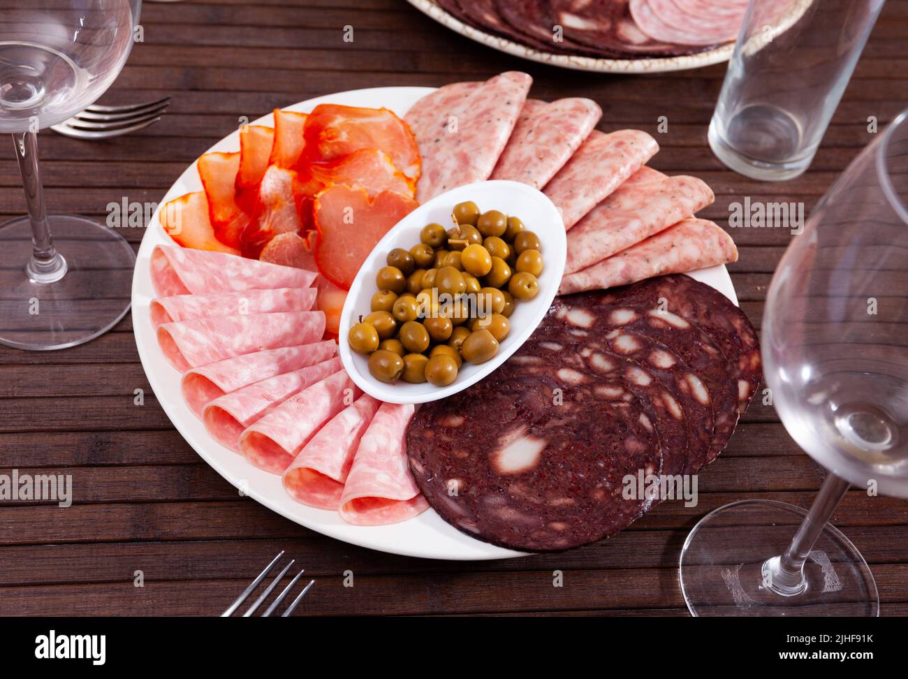 Antipasto platter with various meat and olives Stock Photo