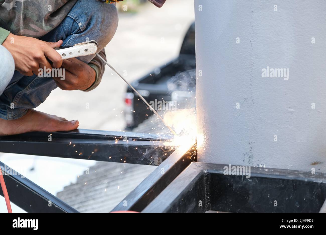 The welder is welding the steel structure to add to the house. Stock Photo