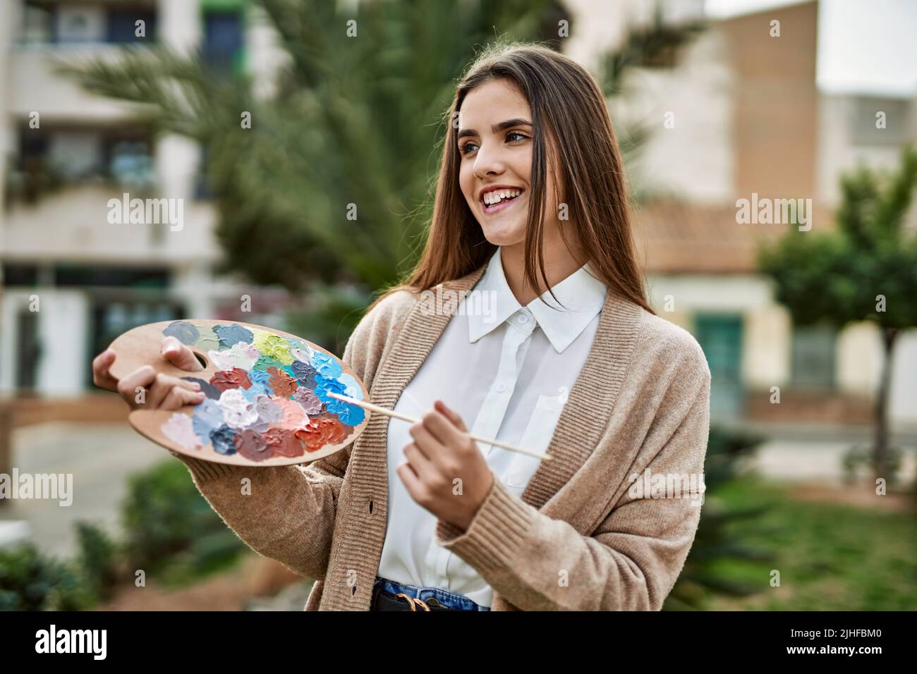 Young hispanic artist girl smiling happy painting at the city Stock ...