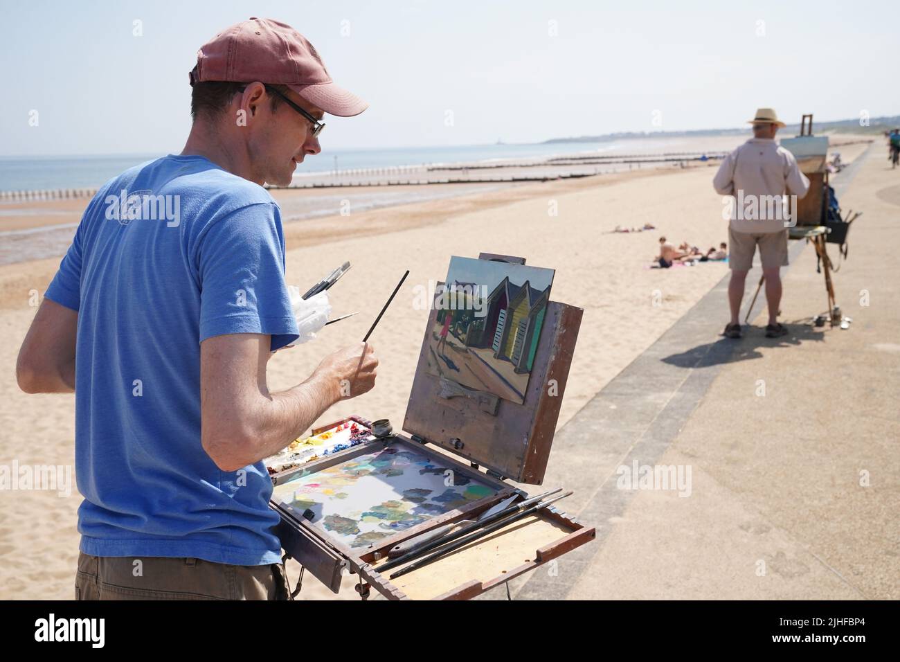 Artists painting the beach huts on Blyth beach, Northumberland, on the north east coast, as the heatwave sweeps across England. Picture date: Monday July 18, 2022. Stock Photo