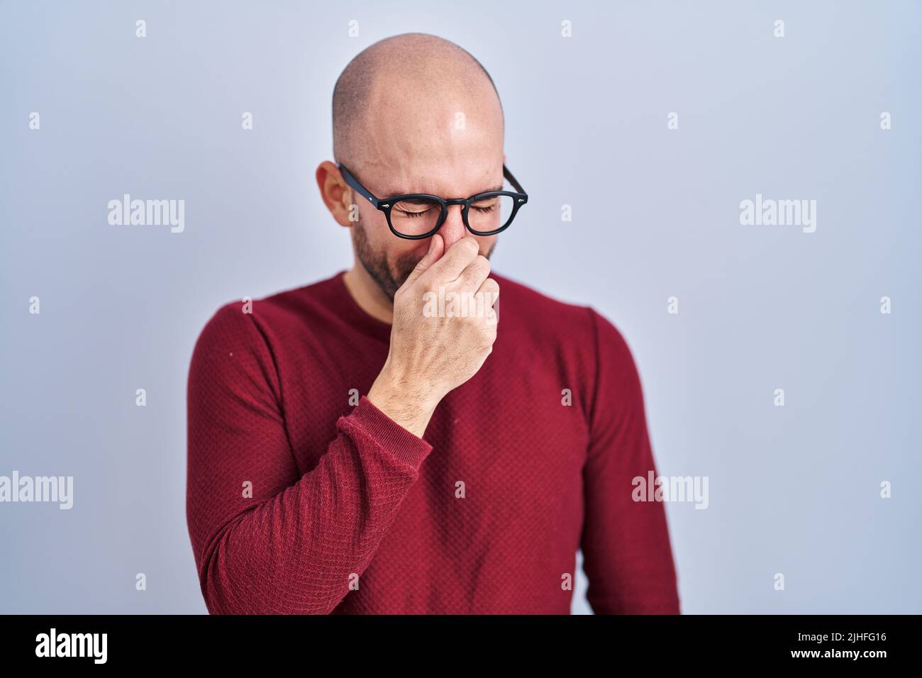 Young bald man with beard standing over white background wearing