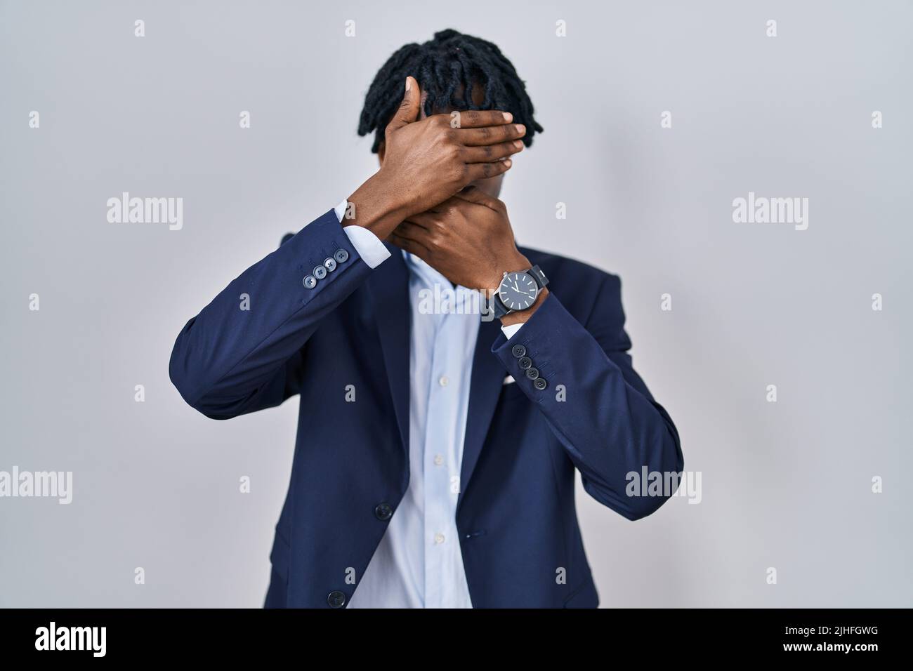 Young african man with dreadlocks wearing business jacket over white ...