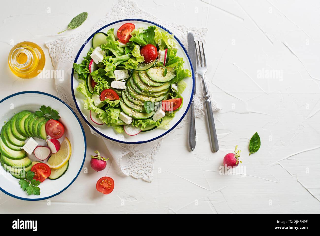 Green salad with avocado, tomato, feta cheese and fresh vegetables Stock Photo