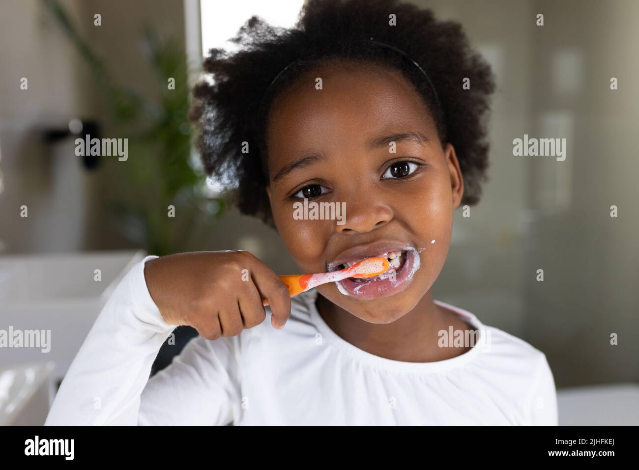 Image of african american girl brushing teeth Stock Photo