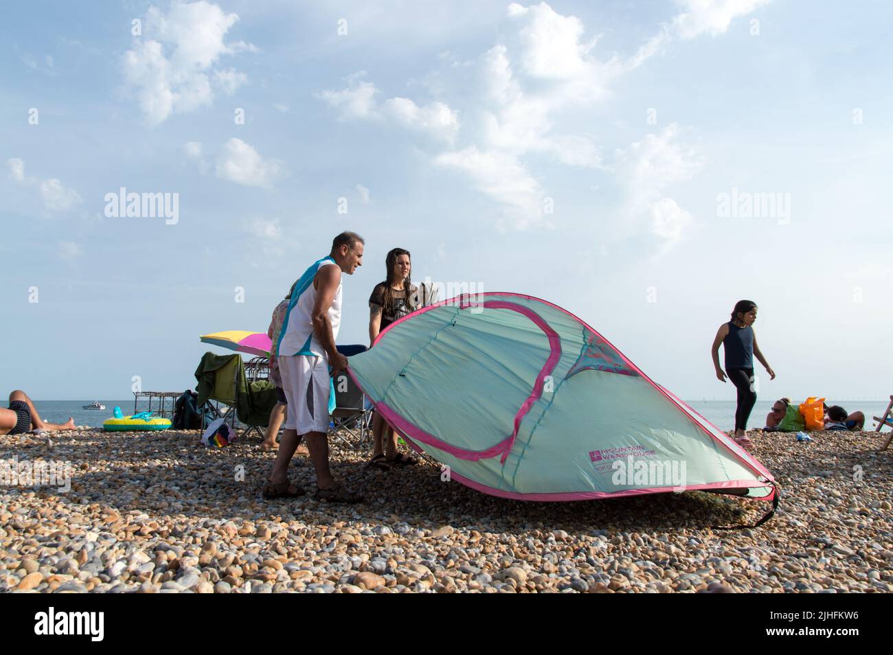 Couple putting up tent in Beach during hot weather Stock Photo