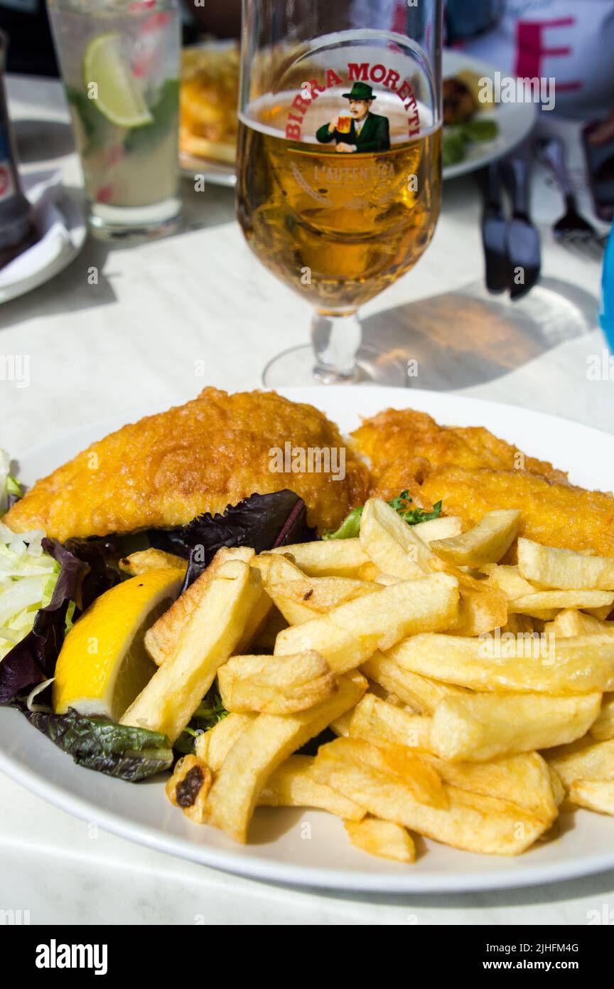 Authentic fish and chips on table with beer in a restaurant at Brighton