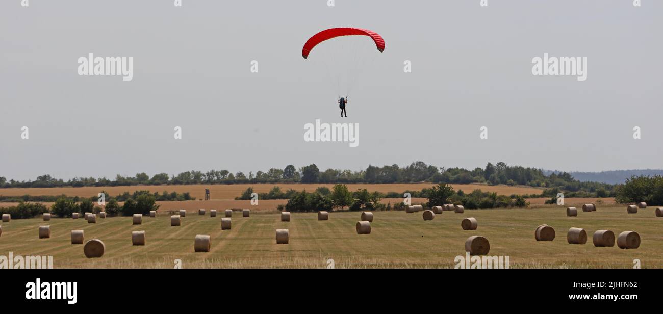 Osterwieck, Germany. 18th July, 2022. A paraglider hovers in the sky in the Harz region near Osterwieck. From Tuesday, temperatures are expected to rise to over 30 degrees. Credit: Matthias Bein/dpa/Alamy Live News Stock Photo