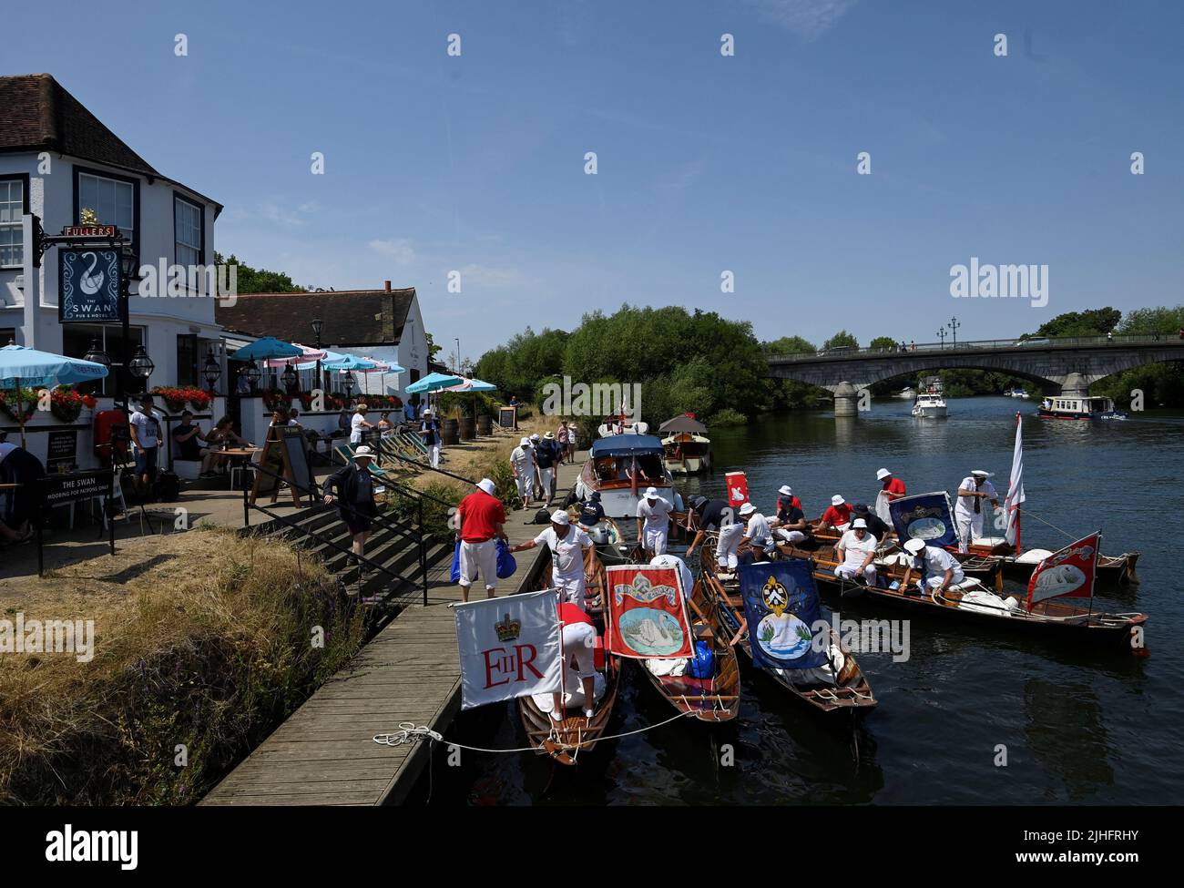 Swan Uppers moor their boats to take a break at The Swan pub during the annual census of the swan population along sections of the River Thames, Shepperton near Windsor, Britain, July 18, 2022. REUTERS/Toby Melville Stock Photo