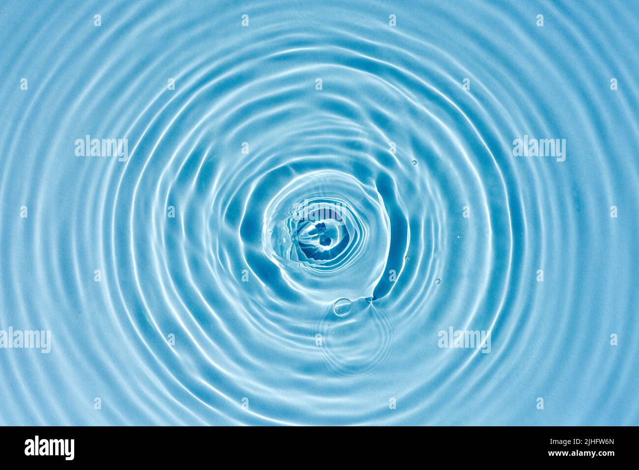 Texture of blue water with rings and ripples from drops. Water background for design and presentation of natural cosmetics. Ecology, cleanliness conce Stock Photo