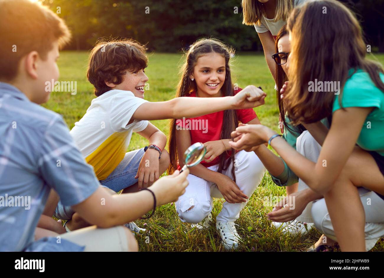 Group of happy school kids learning about environment and insects during field trip Stock Photo