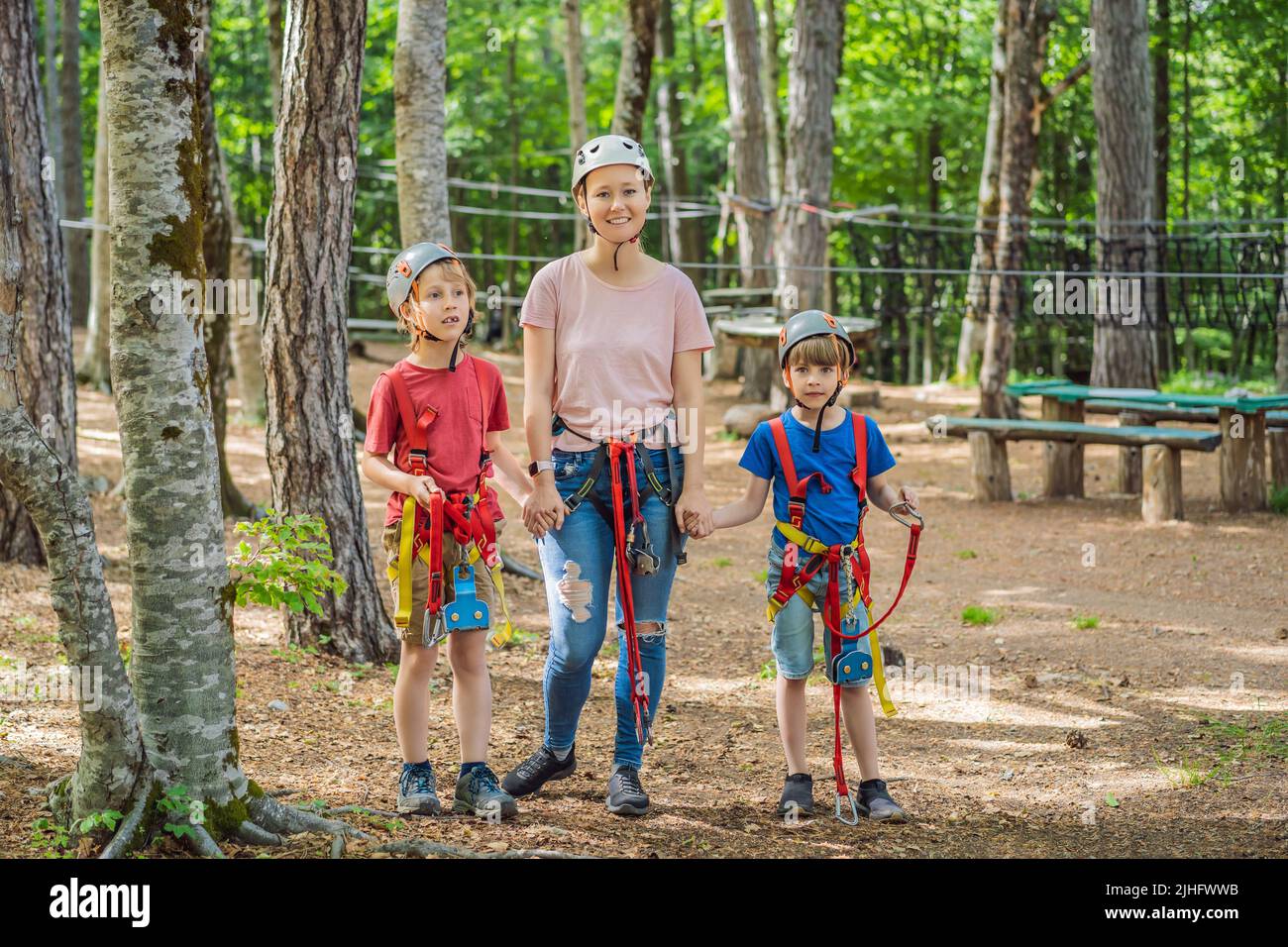 Friends on the ropes course. Young people in safety equipment are ...