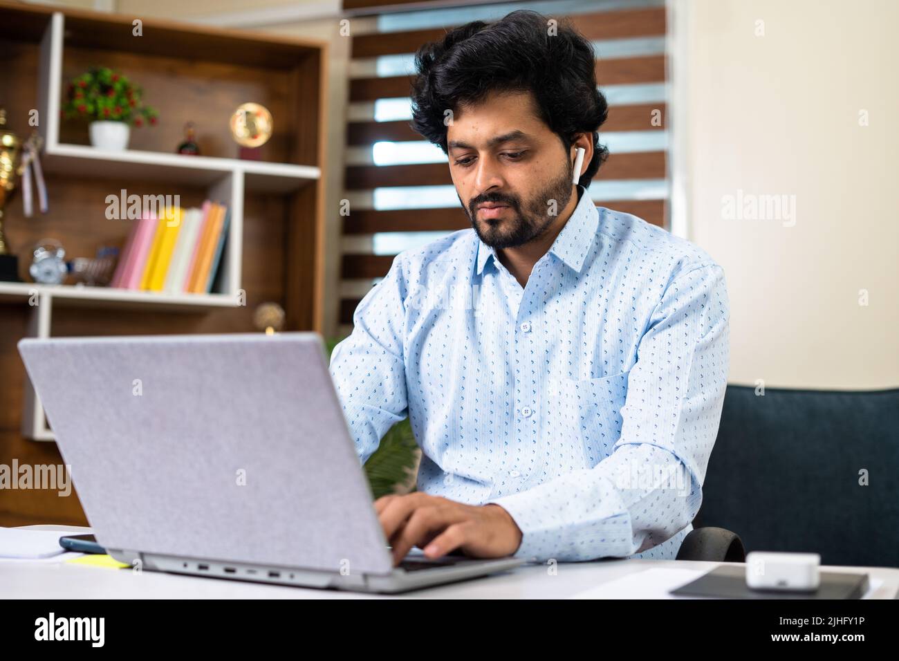 Thoughtful Young corporate employee working laptop while sitting at office - concept of work lifestyle, hard working and dedication Stock Photo