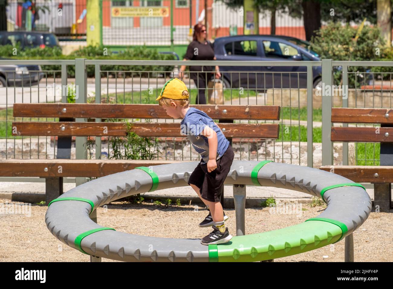 Cute little boy running in the spinner at the playground Stock Photo