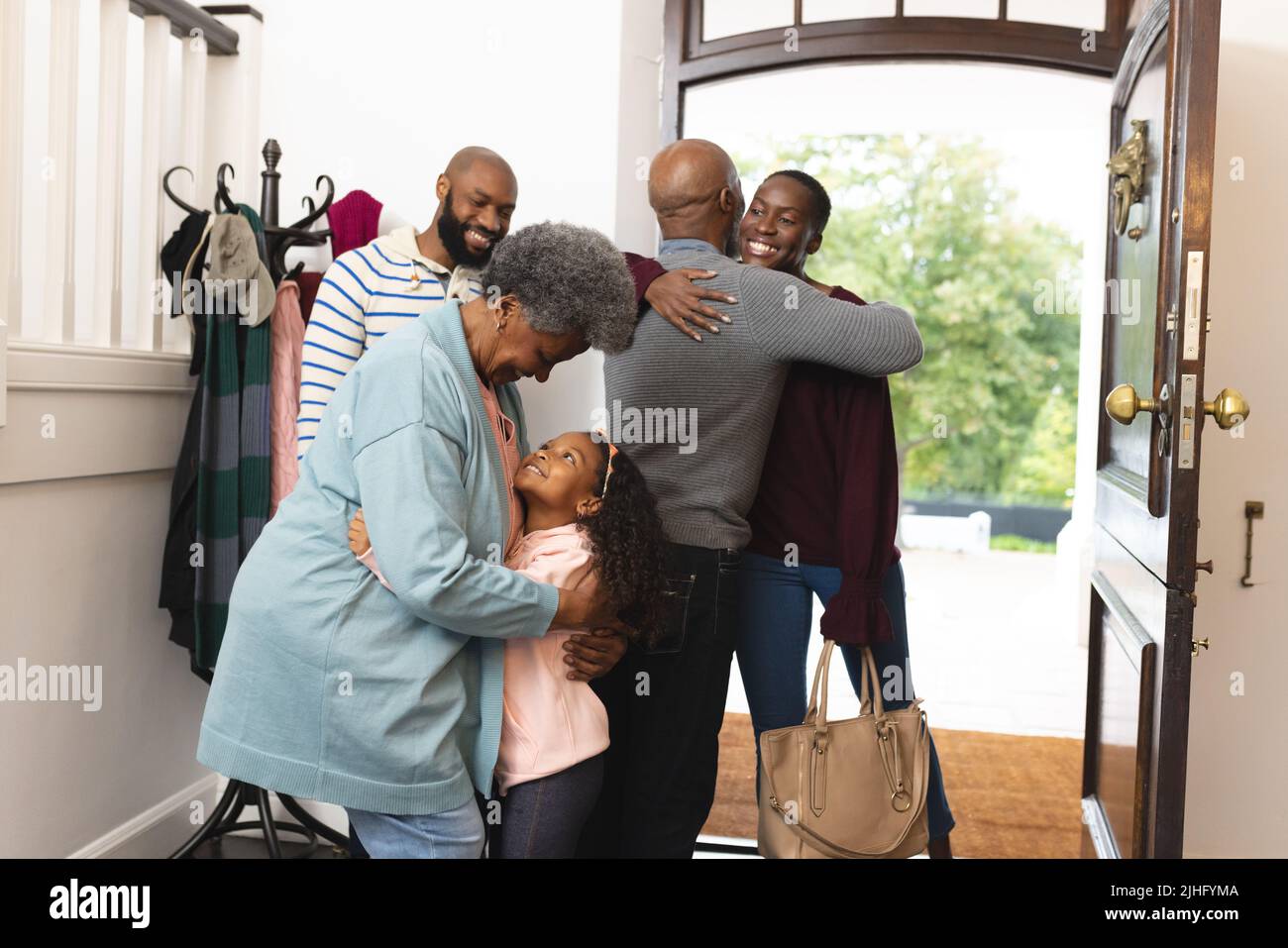 Image of happy multi generation african american family entering house and each other