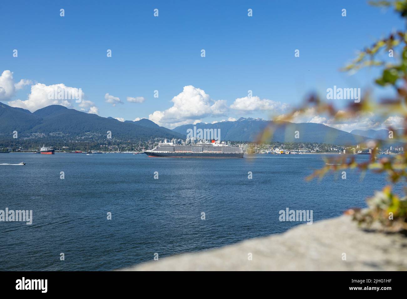 Vancouver, Canada - July 1,2022: Cruise ship is leaving Canada Place pier and heading towards the Lions Gate Bridge. North Vancouver in the background Stock Photo