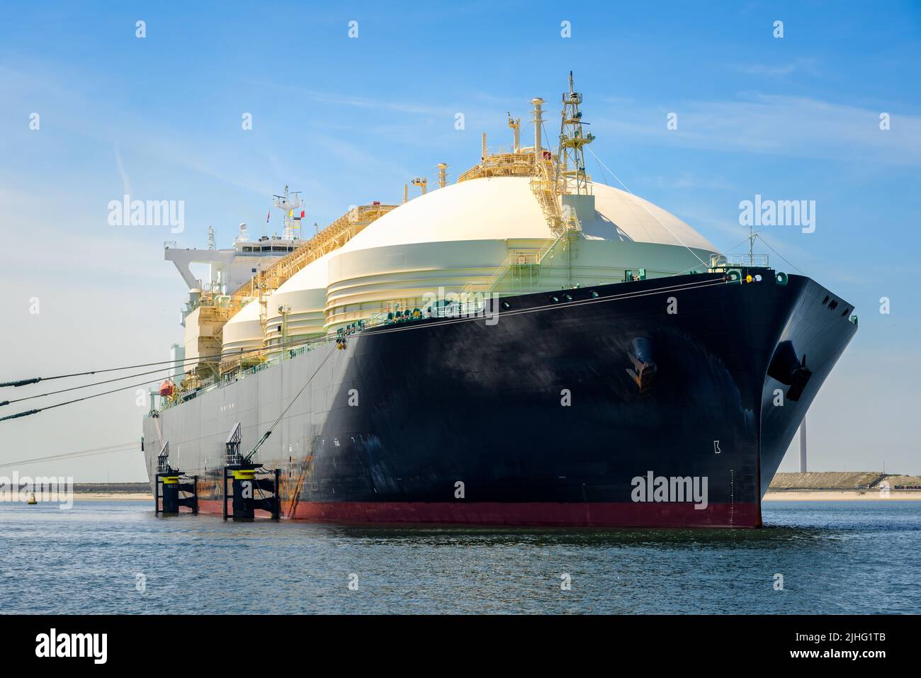 Low angle view of a large LNG tanker ship in a harbour on a clear summer day Stock Photo