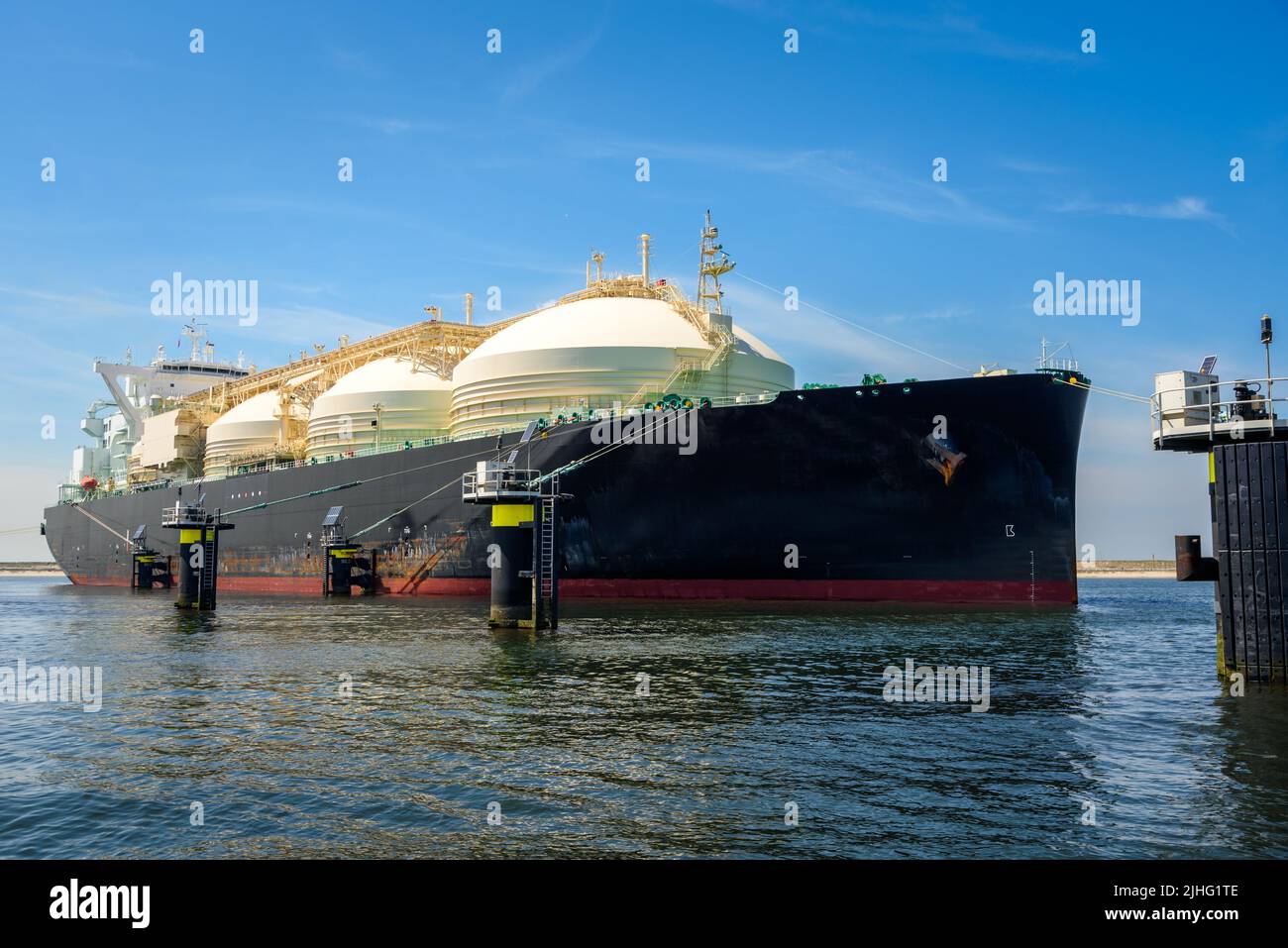 Large LNG tanker in a  harbour under blue sky in summer Stock Photo