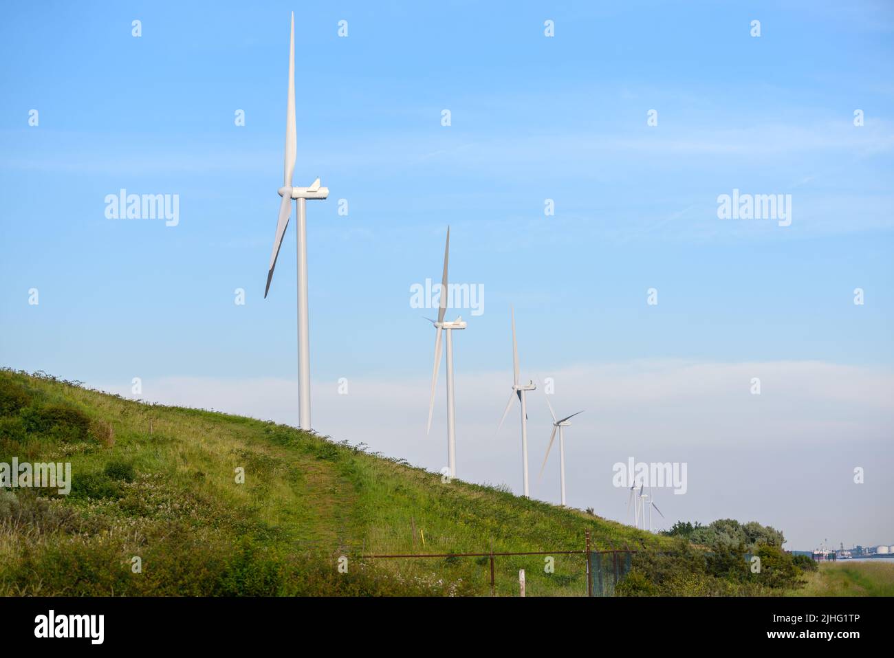 Row of wind turbines against clear sky in summer Stock Photo