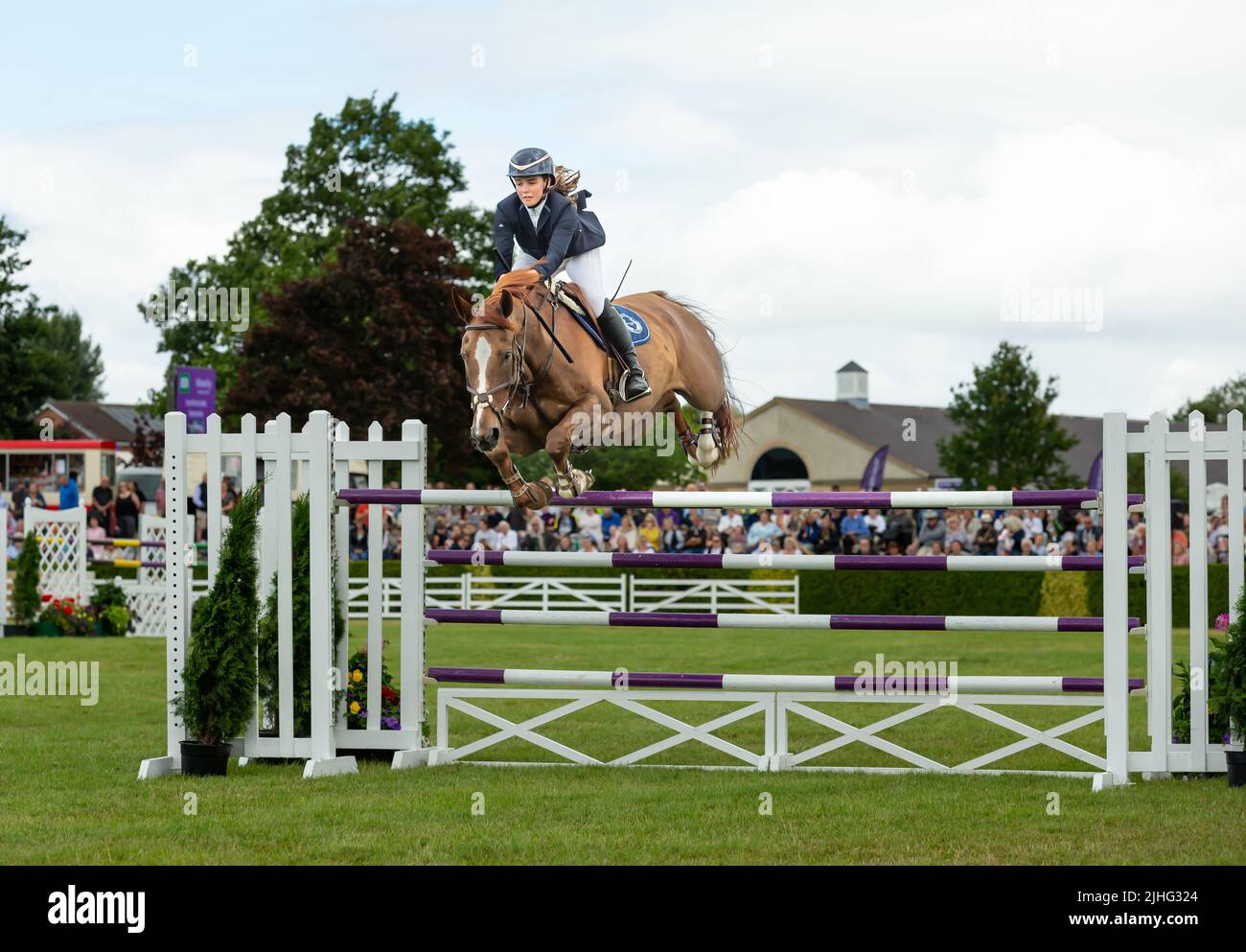 Great Yorkshire Show, Harrogate, UK. July 15, 2022. Young female rider and her horse jumping clear over the poles, main ring show jumping course at th Stock Photo