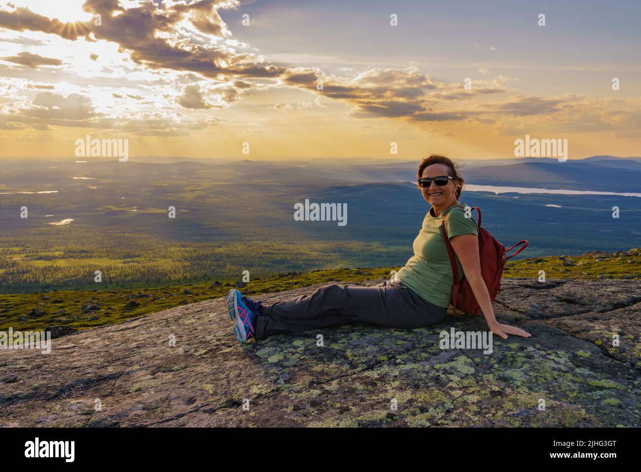 Woman sitting on mountain enjoying the view from Mount Dundret over Laponia, Gällivare county, Swedish Lapland, Sweden Stock Photo