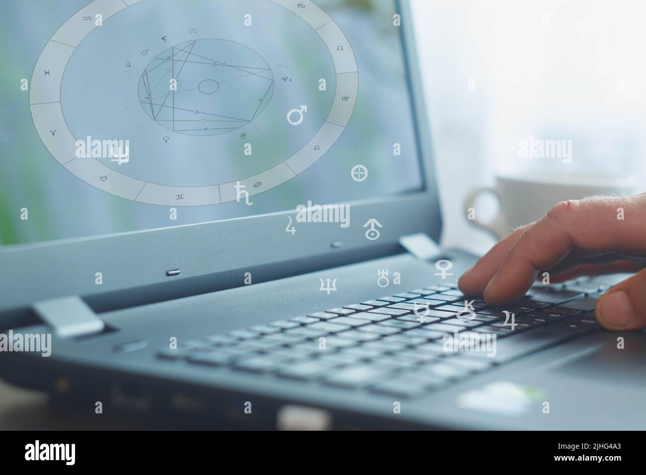 The workplace of a modern advanced astrologer. Laptop on the table for ...