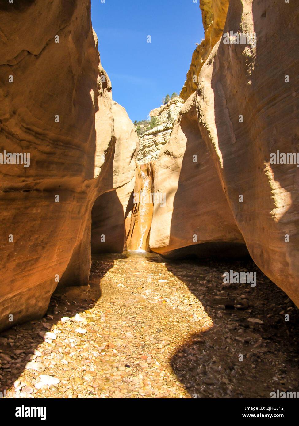 A small waterfall at the end of one of the Willis Creek slot canyons, in Southern Utah, USA, on a clear sunny day. Stock Photo