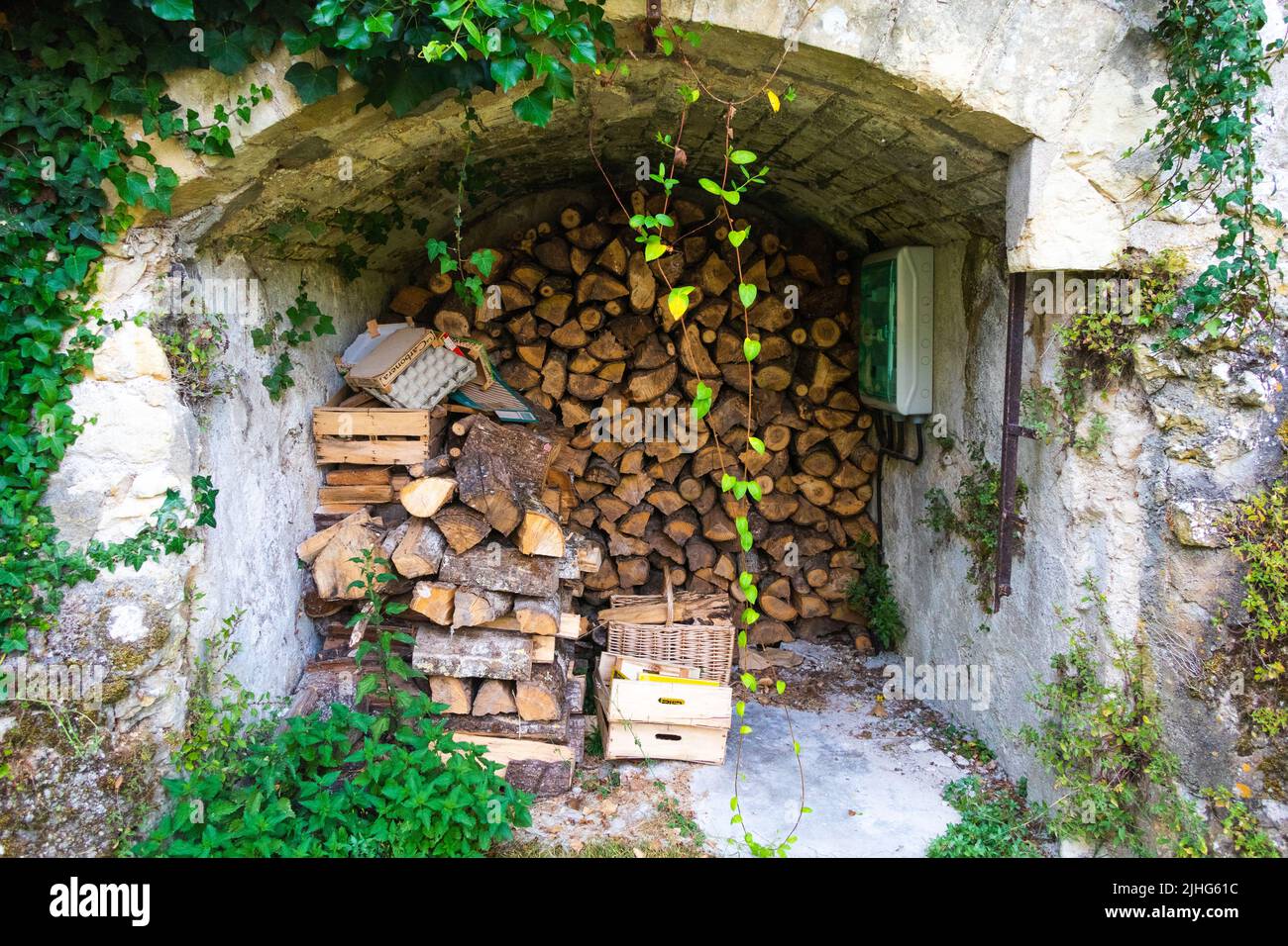 Log store with chopped logs stacked in log store in garden Loire Valley France Stock Photo