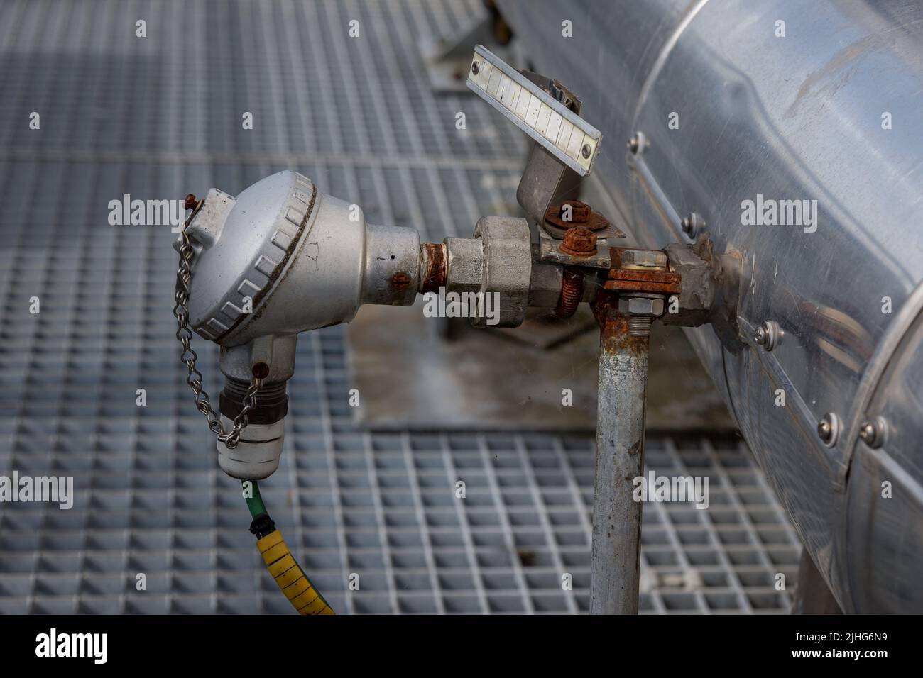 A metal thermocouple in an industrial environment, placed to measure and monitor the temperature in an existing process. Stock Photo