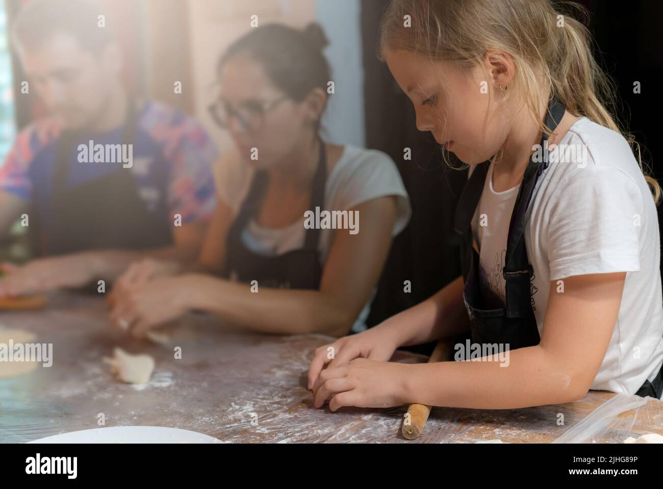 Chengdu, China - July 2019 : Caucasian girl child learning the art of making of traditional chinese dumplings during cooking class in a travellers hos Stock Photo