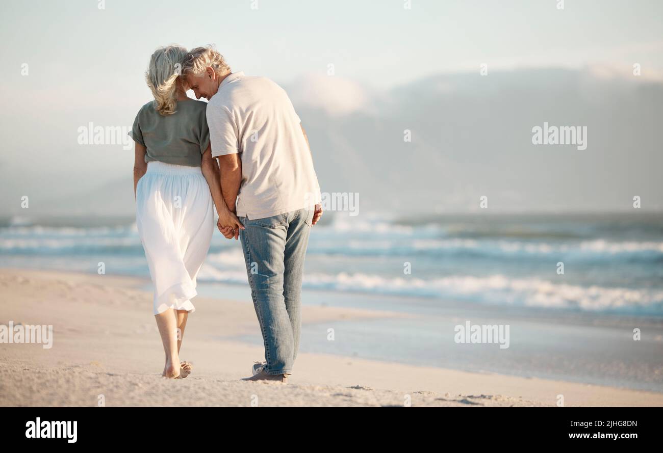 Back of a senior couple walking on a beach together. Senior couple ...
