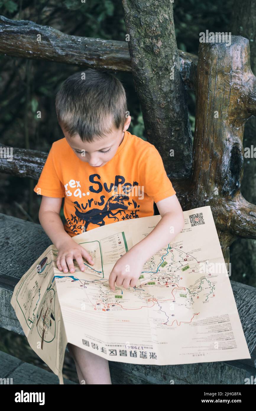 Zhangjiajie, China - August 2019 : oung boy looking at map while ...