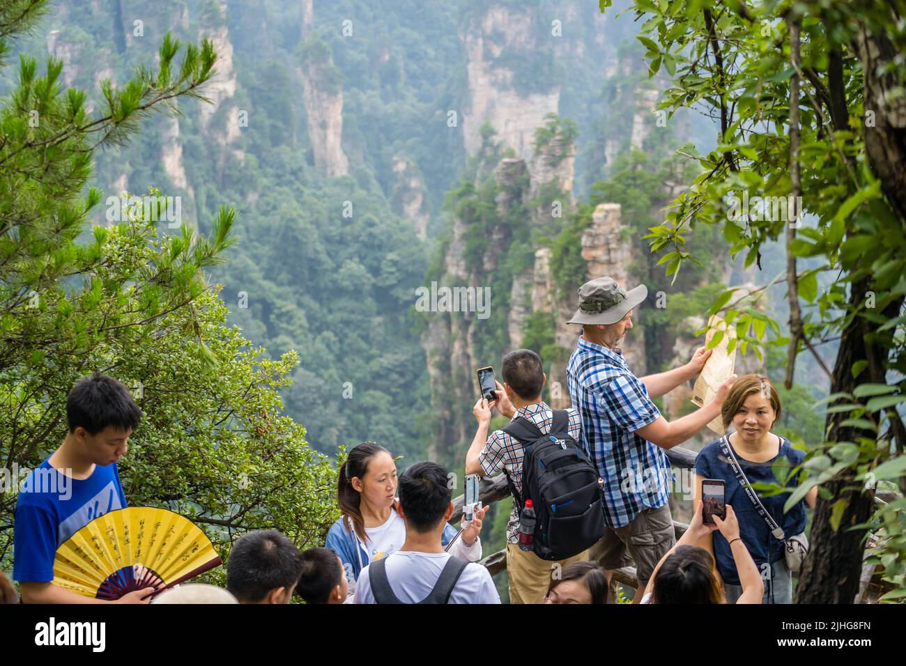 Zhangjiajie, China - August 2019 : Tourists taking pictures on mobile phones on the viewpoint in Tianzi mountain range, Avatar mountains nature park Stock Photo