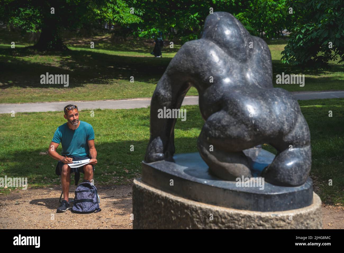 London, UK - June 2020 : Artists sitting in front of a marble giant black gorilla statue and making a sketch of it, picture taken in summer in Crystal Stock Photo