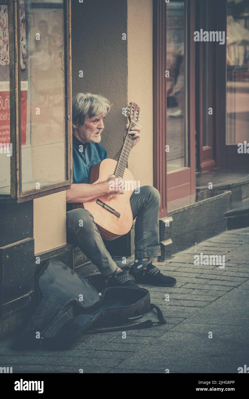 Torun, Poland - August 2020 : Street busker playing guitar in Torun Old Town Stock Photo