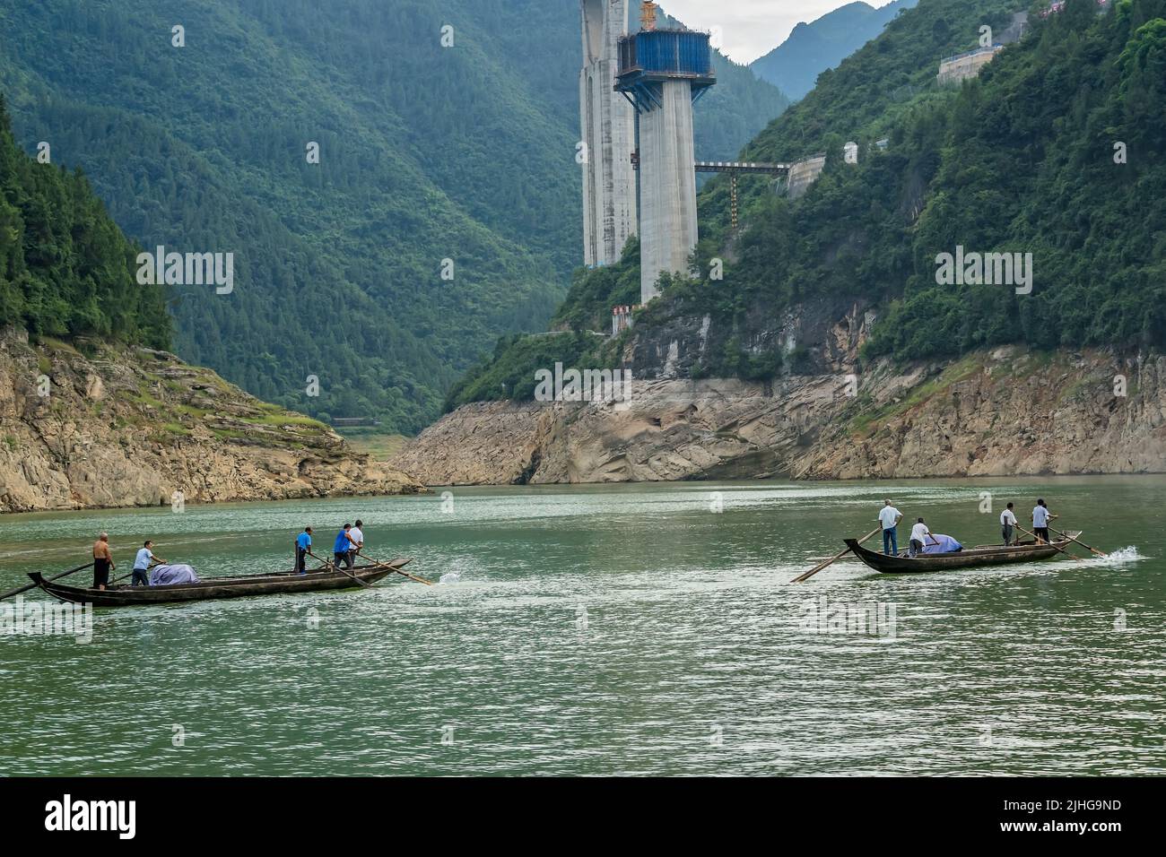 Yangtze River, China - August 2019 : Men catching fish from a small crowded fisherman boats on the Shennong Xi Stream, estuary of the mighty Yangtze r Stock Photo