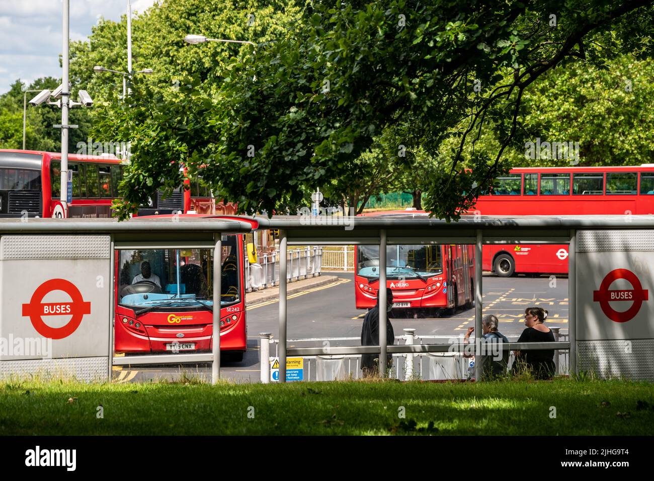 London, UK - June 2020 : People commuting waiting for the buses departing from the Crystal Palace bus station on a busy London Street in summer Stock Photo