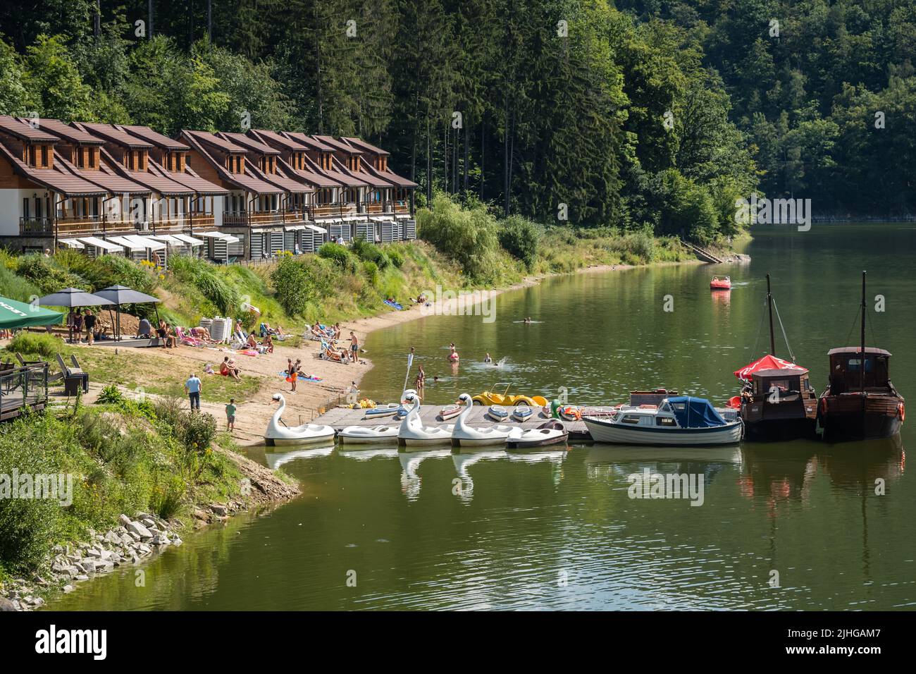 Zagorze Slaskie, Poland - August 2020 : Water cycle boats and small yachts in front of Holiday let homes and bungalows on the shore of Zagorze Slaskie Stock Photo