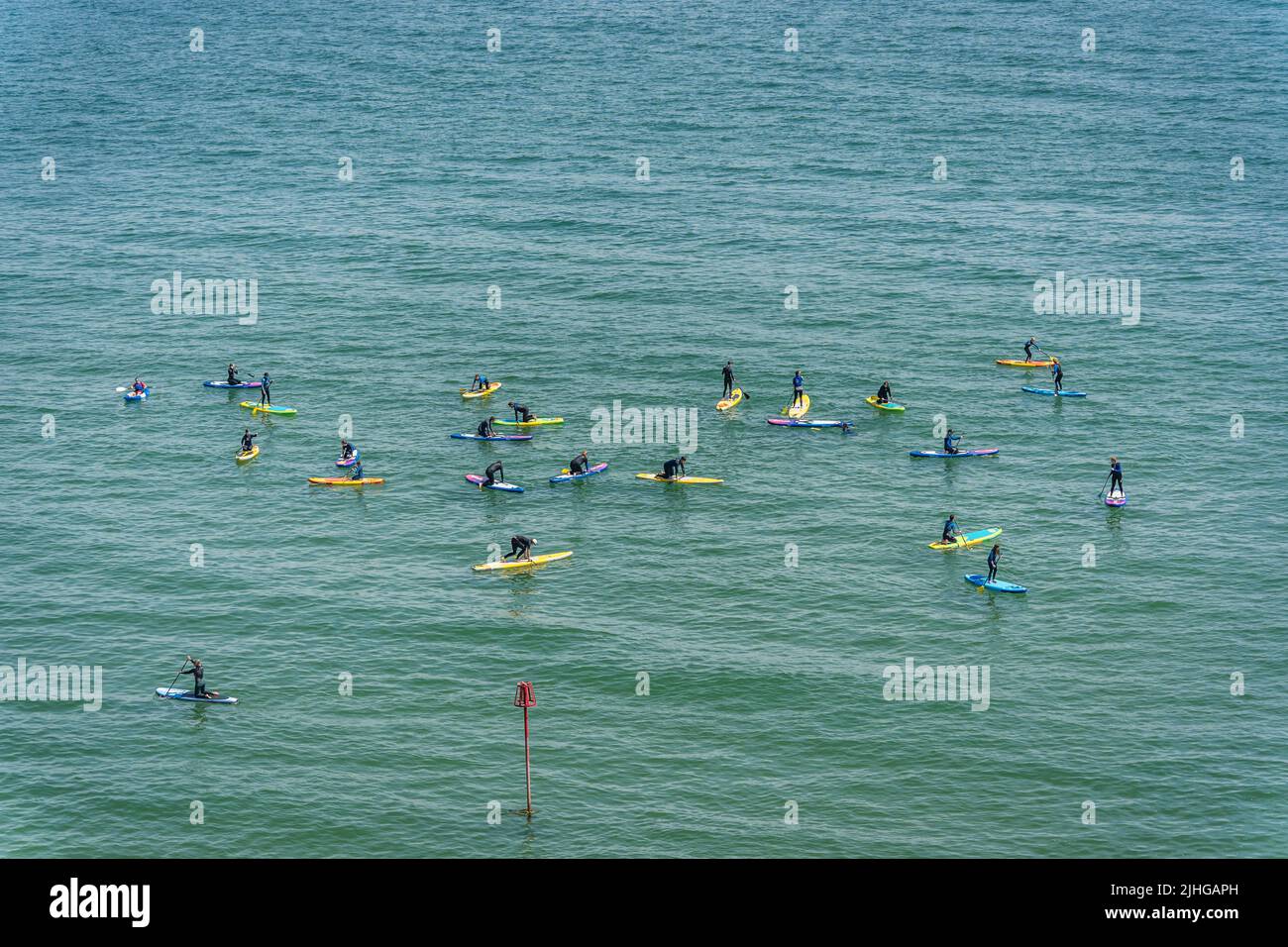 Tenby, Wales - May 2021 : Swimmers Paddle boarding on a hot day in Tenby coast , Carmarthen Bay, Pembrokeshire Stock Photo