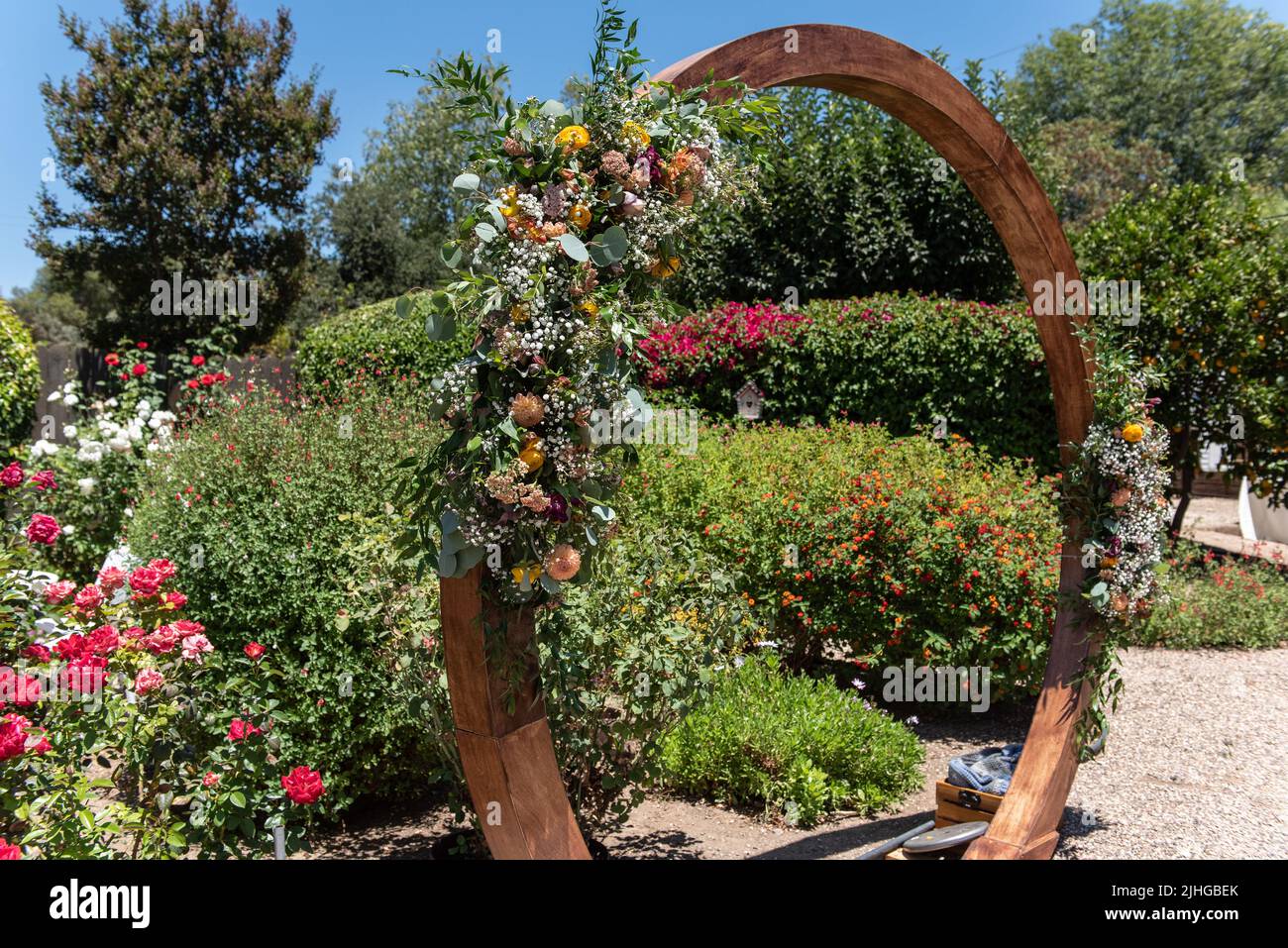 Wooden circle arch decorated with baby's breath flowers makes a perfect altar for the outdoor backyard wedding. Stock Photo
