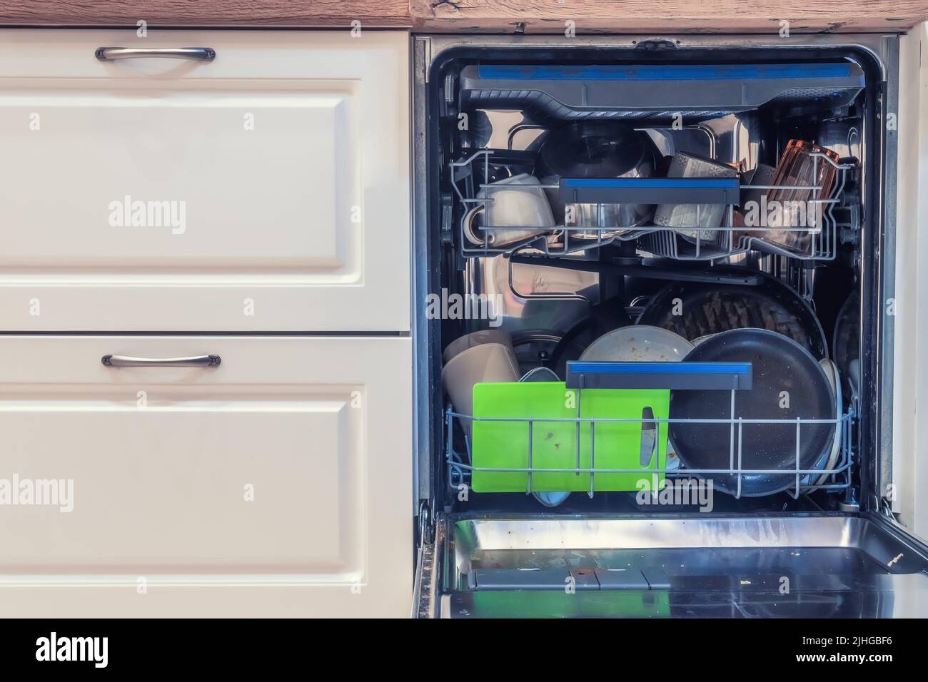 A dishwasher filled with dirty dishes before washing. Dishwasher with