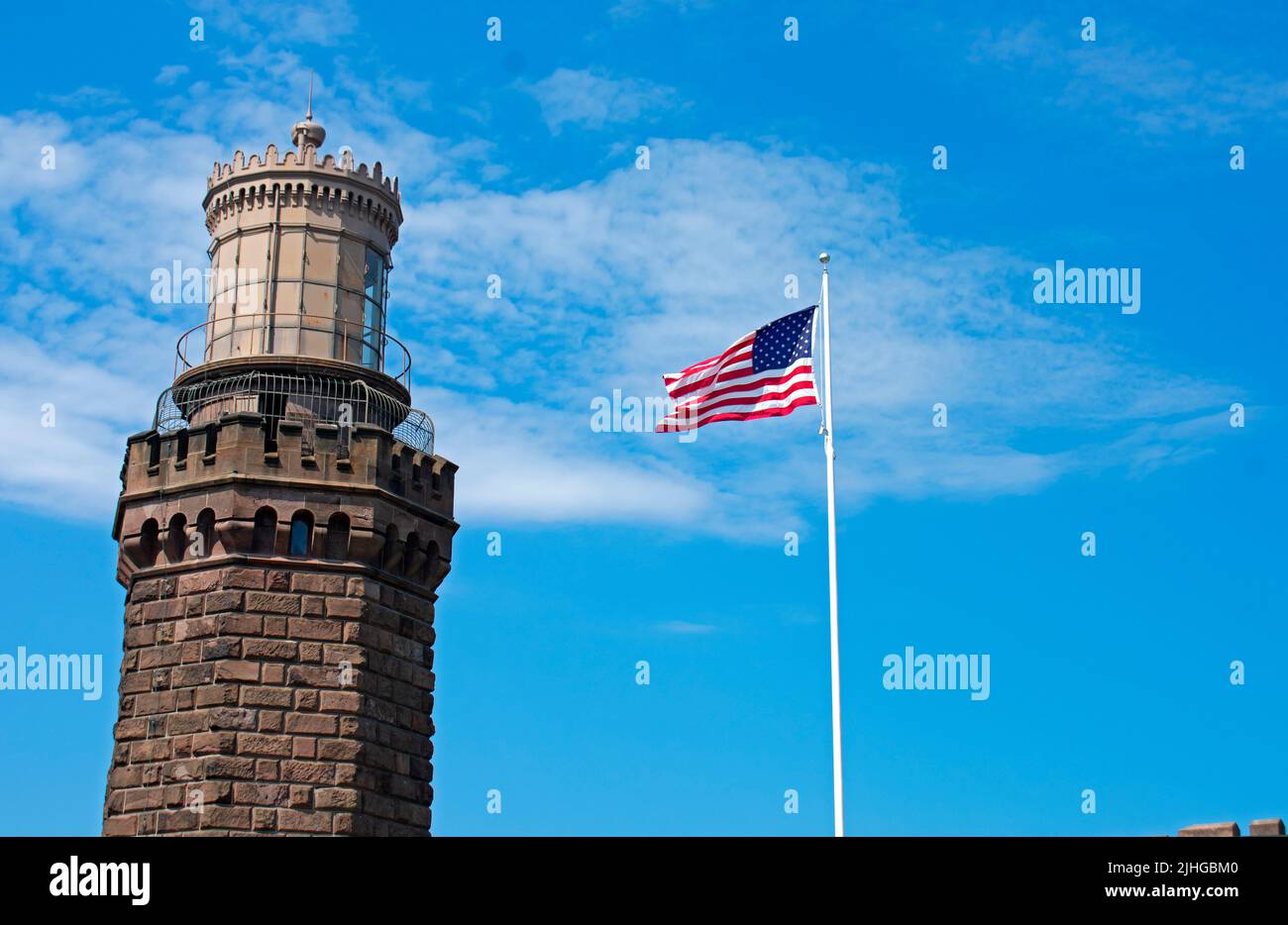 United States flag waving in the breeze next to the north tower of the historic Navesink Twin Lighthouses in Highlands, New Jersey, USA -10 Stock Photo