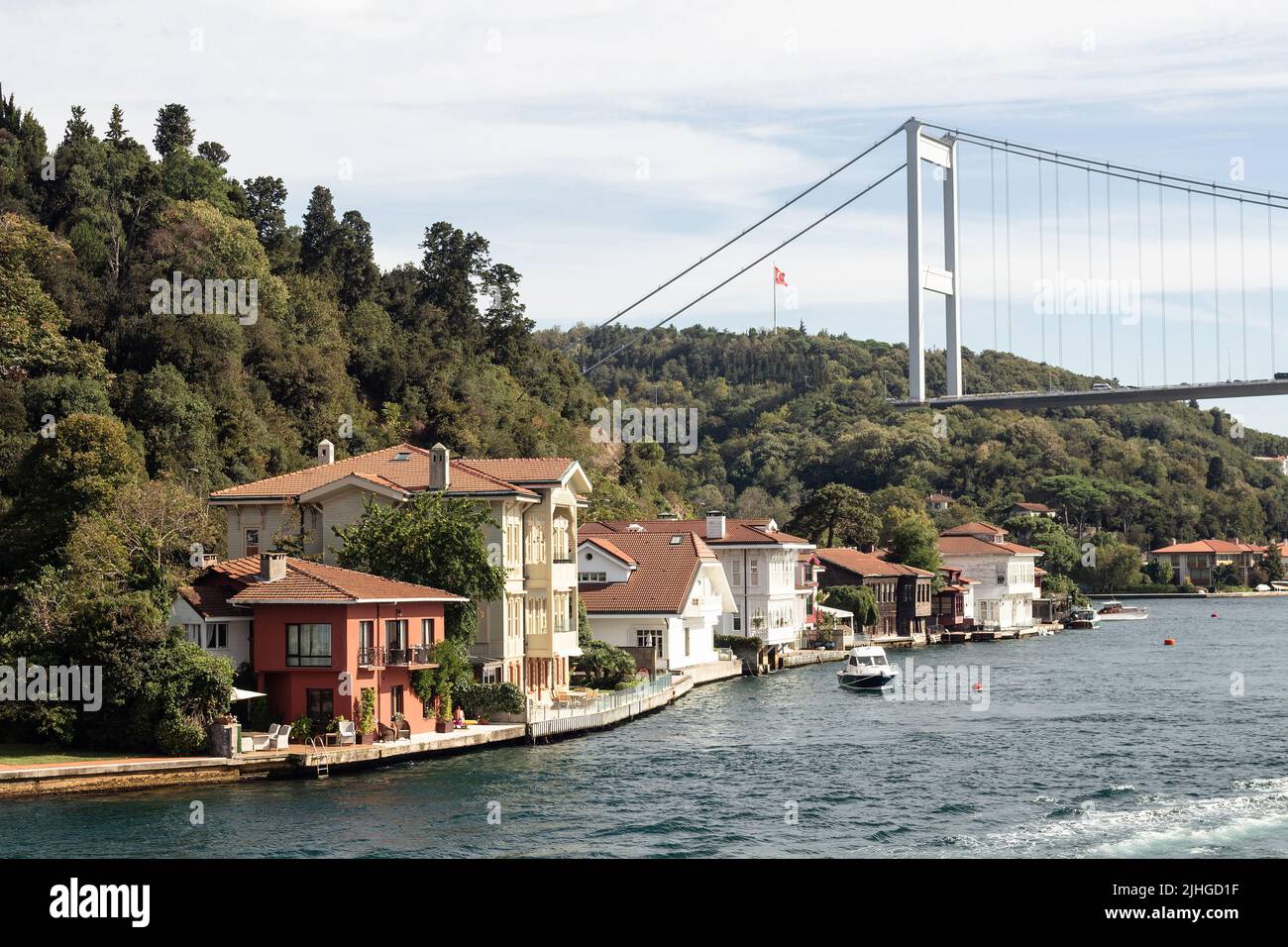 View of historical, traditional mansions by Bosphorus in Kanlica area of Asian side of Istanbul. Boats and FSM bridge are also in the view. It is a su Stock Photo