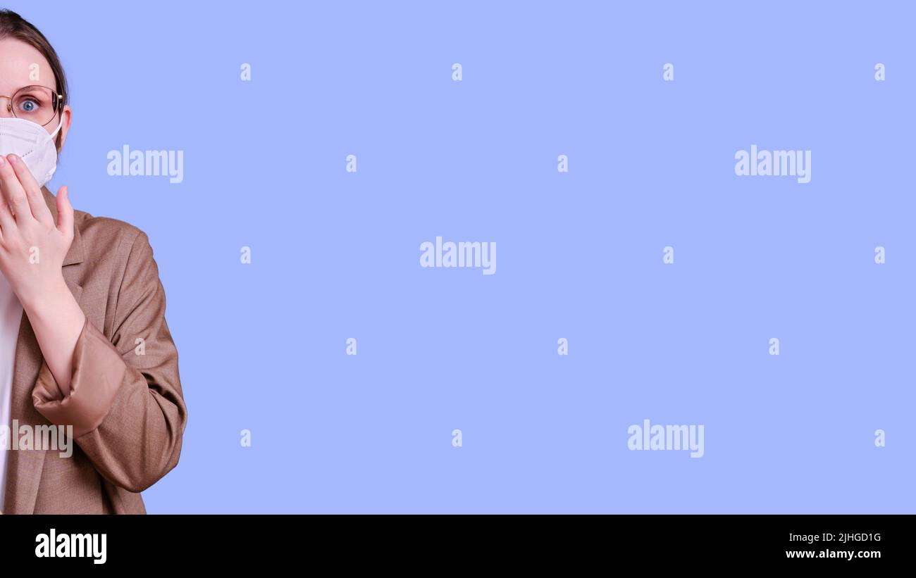 Scared woman teacher in medical face mask on studio purple background ...