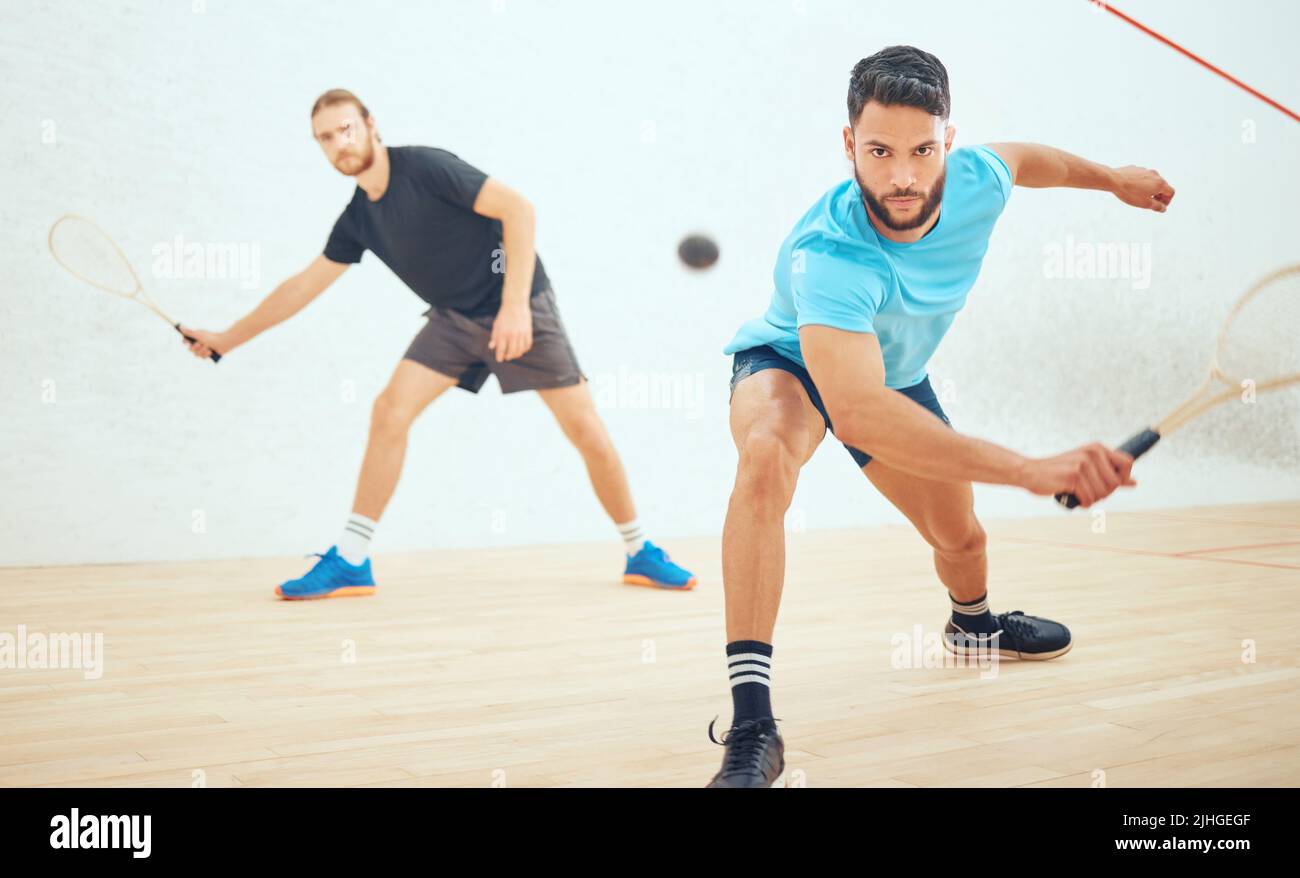 Two athletic squash players playing match during competitive court game