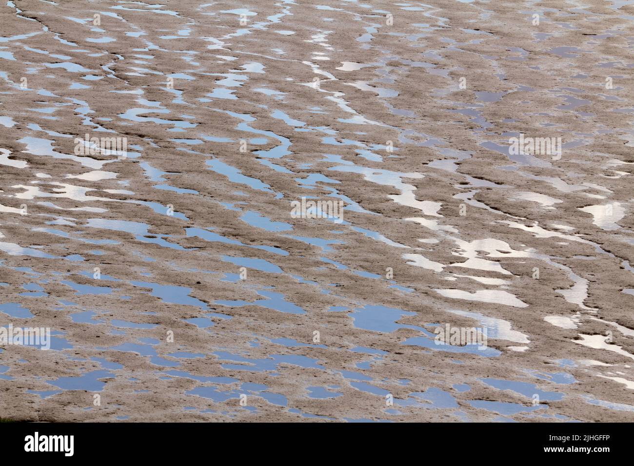 Mud flats low tide severn estuary newport south wales nature reserve abstract shapes in wet puddles of tidal carved depressions backgound textures Stock Photo